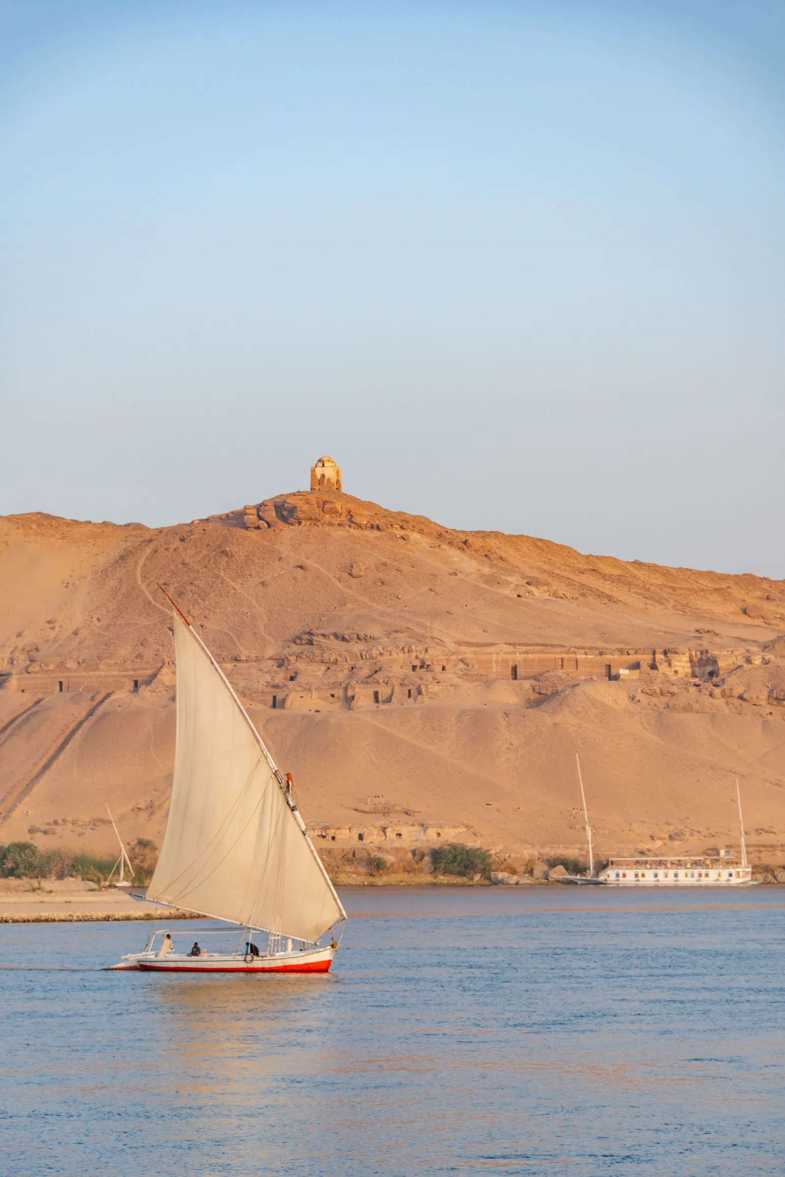 A felucca sailing on the Nile below the desert hills at Aswan
