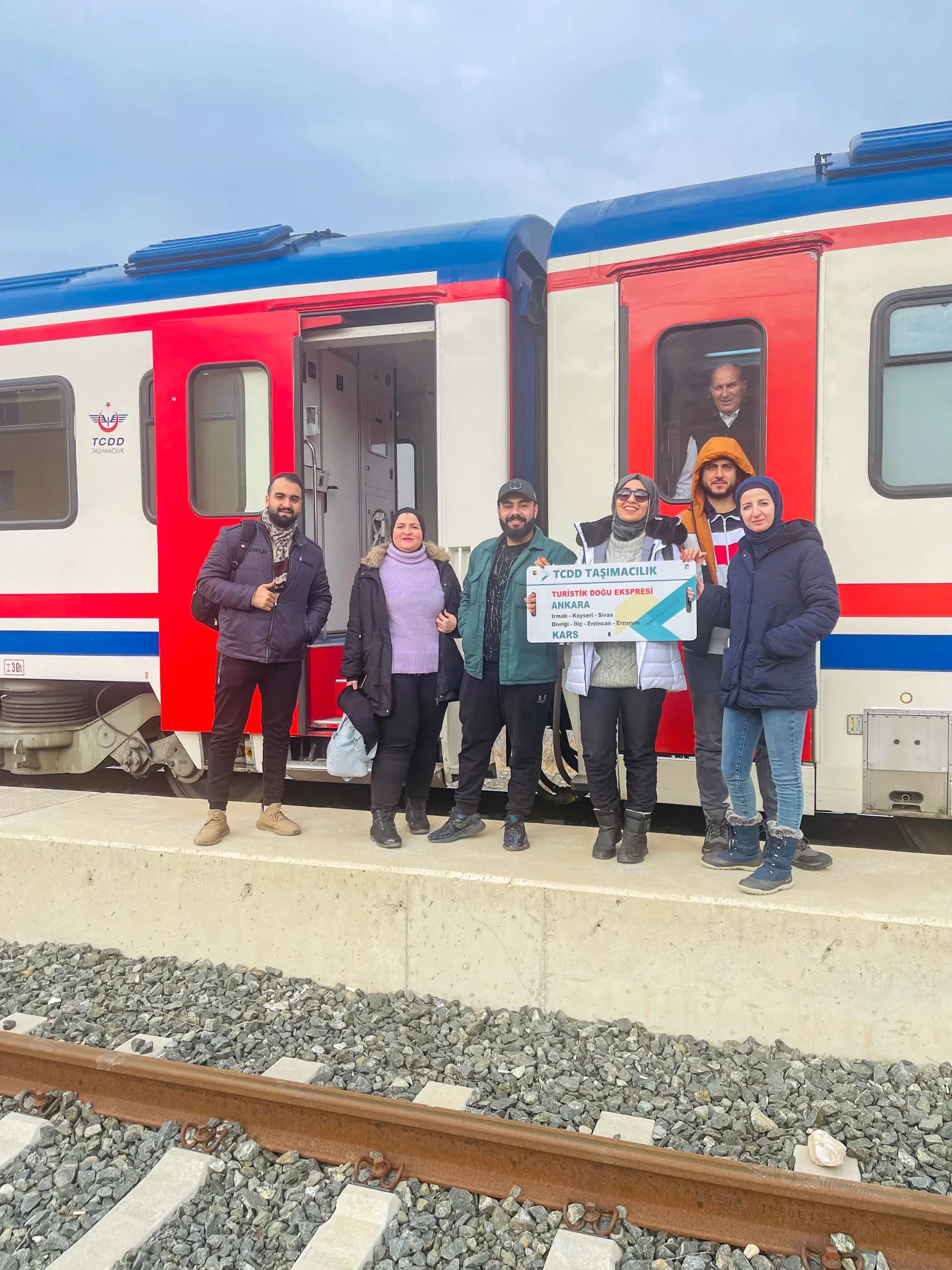 A group beside a train on a platform in Turkey
